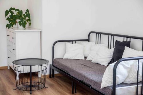 una cama negra con almohadas blancas y una mesa en Jitkovsky mlyn, en Chotěboř