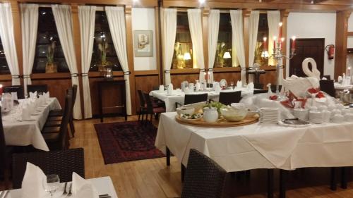 jadalnia z białymi stołami i krzesłami w obiekcie Landgasthof & Hotel "Zum Schwan" GmbH w mieście Trippstadt
