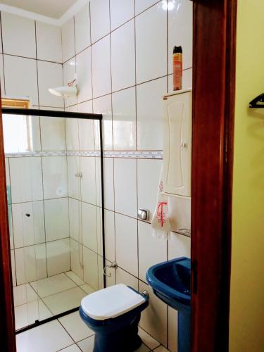 a bathroom with a blue toilet and a shower at Sítio Flora Rei in Holambra