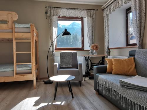 a living room with a couch and a chair and a bed at Apartma Pr Gatej in Bohinj
