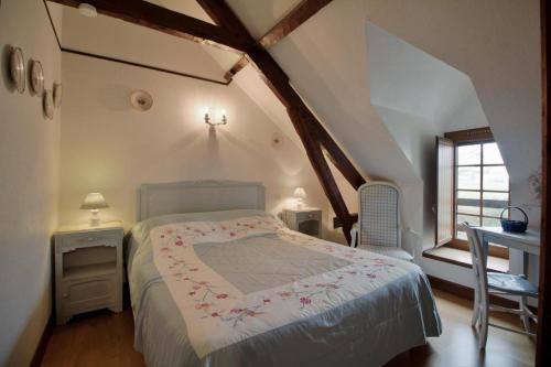 um quarto com uma cama, uma mesa e uma janela em Anousta em Loubajac