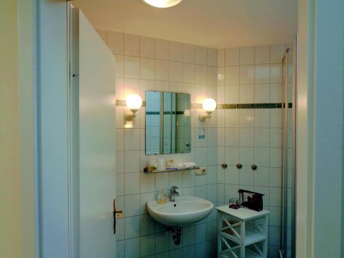 a bathroom with a sink and a mirror at Gästehaus Schiemann in Teterow