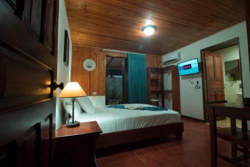 1 dormitorio con 1 cama y 1 mesa con lámpara en Tirimbina Rainforest Lodge en Sarapiquí