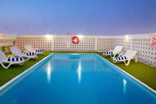 a swimming pool with chairs and a pool at Landmark Hotel in Dubai