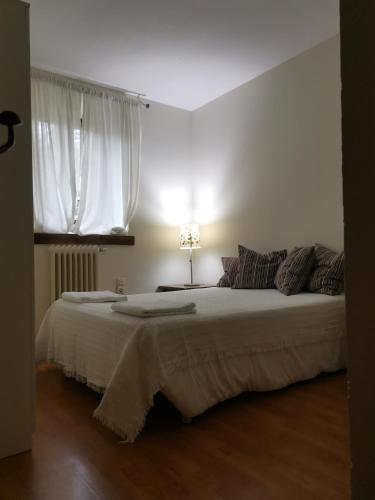 a white bedroom with two beds and a window at Casa Rural la Insula in Santa María de la Alameda