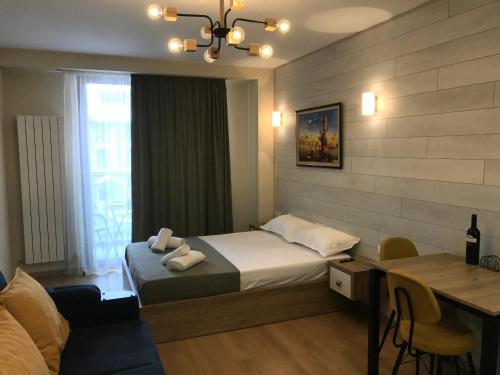 a hotel room with a bed and a table and a desk at New Gudauri, Red Co, Loft 1 in Gudauri