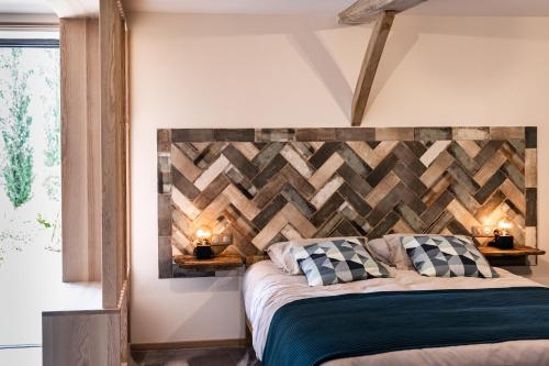 a bedroom with a bed with a wooden headboard at La Suite de l'Etoile in Longmesnil