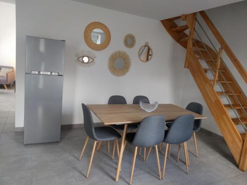 une salle à manger avec une table et des chaises en bois dans l'établissement Maison Jean-Moulin, jardin, spacieuse, 24h Mans, zoo, Prytanée, 3 chbres, 6 pers, à La Flèche