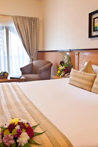 a hotel room with a bed with flowers on it at Landmark Plaza Hotel in Dubai