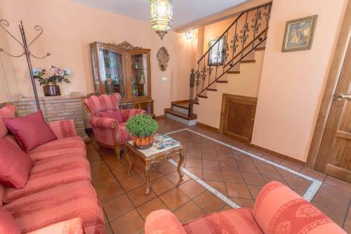 a living room with red furniture and a staircase at Balcones con Encanto - vistas al conjunto monumental Patrimonio de la Humanidad in Úbeda