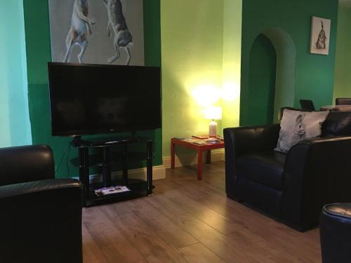 ein Wohnzimmer mit einem Sofa und einem Flachbild-TV in der Unterkunft City Living in Norwich