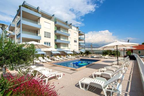 - une piscine avec des chaises et des parasols à côté d'un bâtiment dans l'établissement AS'S, à Split