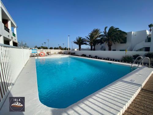 a swimming pool with blue water in a building at Giulia Puerto del Carmen in Puerto del Carmen
