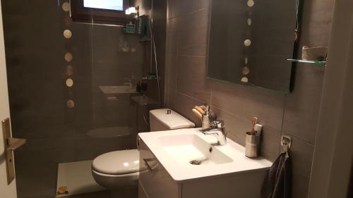 uma casa de banho com um lavatório, um WC e um espelho. em Margouillat chambre d'hôte em Figeac