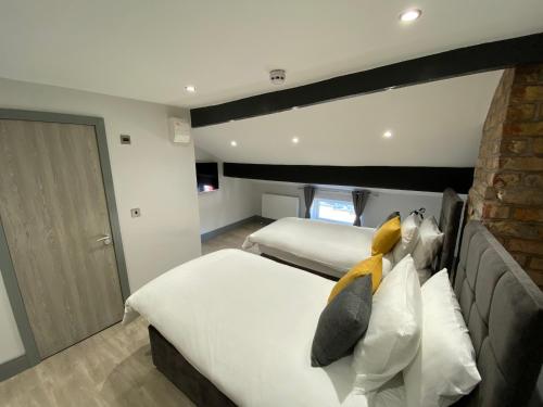 1 Schlafzimmer mit 2 Betten und Ziegelwand in der Unterkunft 6Adelphi in Preston
