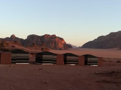 un edificio en el desierto con montañas en el fondo en Wadi Rum en Wadi Rum