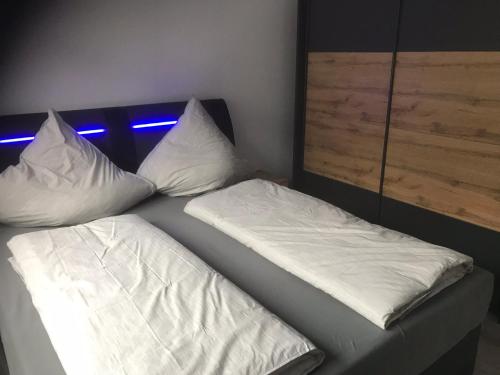 Duas almofadas brancas sentadas numa cama num quarto em Ferienwohnung Wildes Wässerchen em Bad Hersfeld