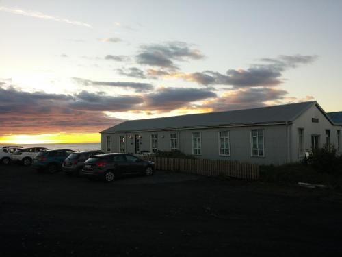 a building with cars parked in a parking lot at Brimslóð Atelier Guesthouse in Blönduós