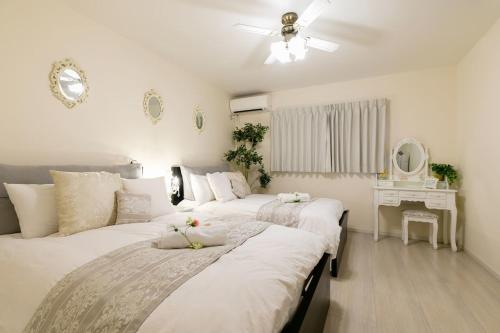 sypialnia z 2 łóżkami i stołem w obiekcie Osaka - House / Vacation STAY 74031 w Osace