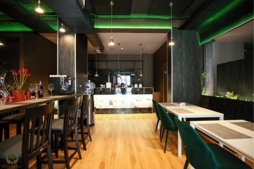 a restaurant with tables and chairs and a bar at Hotel Olive in Vlorë