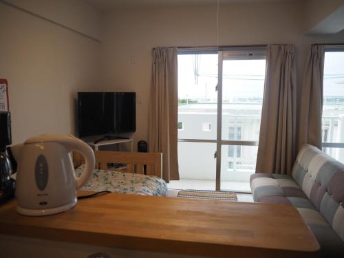 uma sala de estar com um sofá e uma televisão em Sea Turtle / Vacation STAY 5694 em Ilhas Miyako