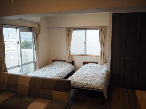 uma sala de estar com duas camas e um sofá em Sea Turtle / Vacation STAY 5694 em Ilhas Miyako