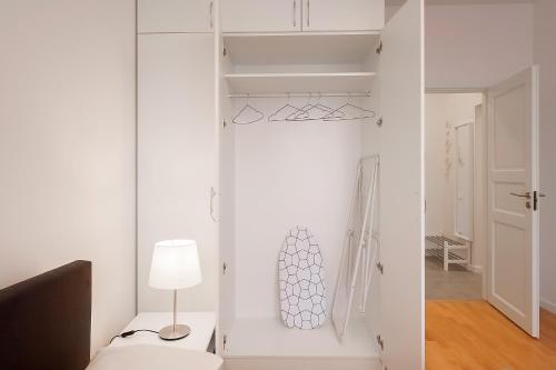 a white room with a white closet with a lamp at Residential Barona Apartments in Riga Centre in Rīga