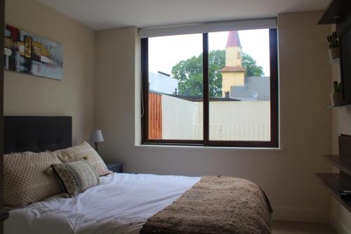a bedroom with a bed and a large window at Hermoso departamento nuevo en costanera de Puerto Varas in Puerto Varas