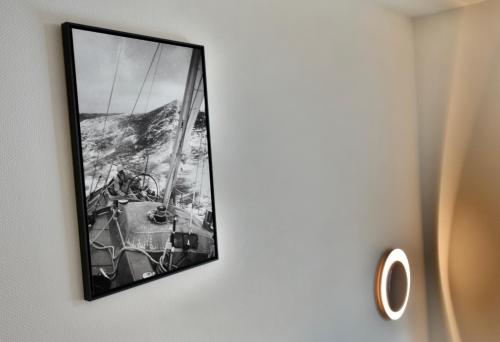 a picture hanging on a wall with a mirror at Hôtel Escale Oceania Lorient in Lorient