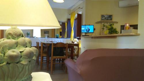 uma sala de estar com uma mesa e um sofá com um candeeiro em La spiaggetta Maladroxia em Maladroxia