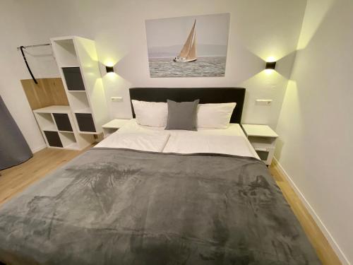 a bedroom with a large bed and a sailboat on the wall at Landhotel Rauber Sankt Wendel in Oberthal