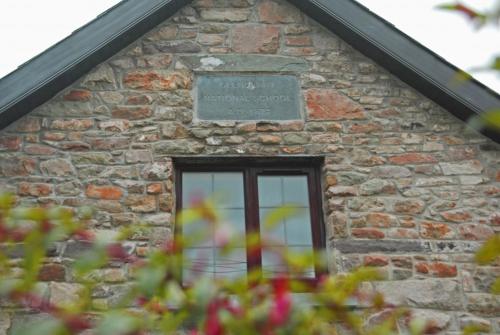 a window of a brick building with a sign on it at The Old School in Ballyheigue