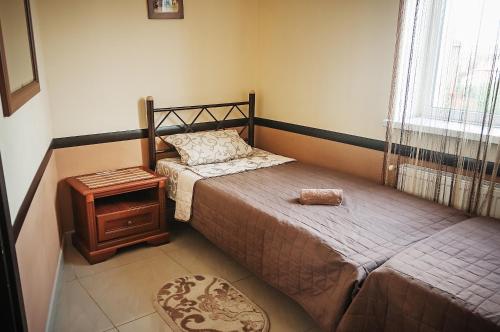 a small bedroom with a bed and a night stand at Avto Spa in Khmelʼnytsʼkyy