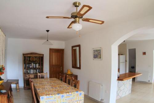ein Wohnzimmer mit einem Tisch und einem Deckenventilator in der Unterkunft Club Villamar - Pearl in Calonge
