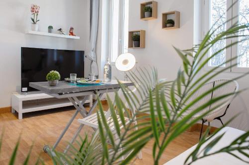 - un salon avec une table et une télévision dans l'établissement GregBnb-com - T2 Design - CLIMATISÉ - WiFi Fibre, à Toulon