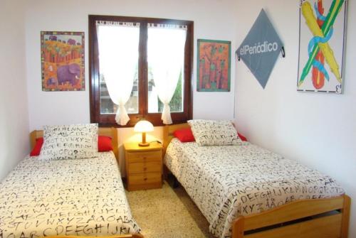 1 dormitorio con 2 camas y ventana en Club Villamar - Tana, en Calonge