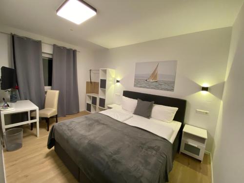 a bedroom with a bed and a desk with a sailboat in it at Landhotel Rauber Sankt Wendel in Oberthal