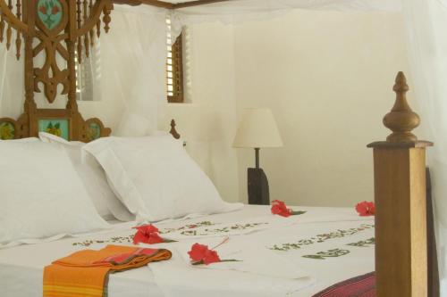 a bedroom with a bed with flowers on it at The Red Pepper House in Lamu