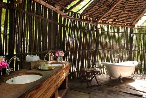 a bathroom with a tub and a sink and a bath tub at The Red Pepper House in Lamu
