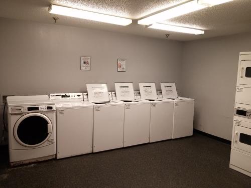 a laundry room with a row of washers and dryers at InTown Suites Extended Stay Memphis TN - Hickory Hill in Memphis