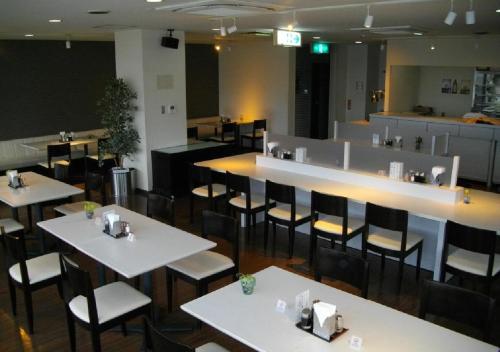 een restaurant met witte tafels en stoelen en een bar bij Okadaya Bayside / Vacation STAY 72738 in Toyohashi