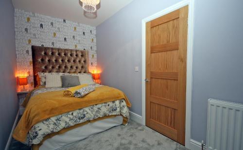 a bedroom with a bed and a wooden door at Moryn. Snowdonia and Anglesey View in Bangor