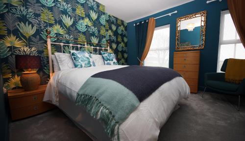 a bedroom with a large bed with blue walls at Moryn. Snowdonia and Anglesey View in Bangor