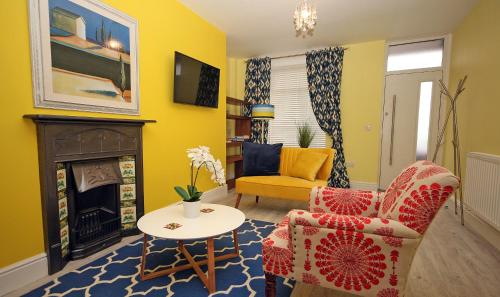 a living room with two chairs and a fireplace at Moryn. Snowdonia and Anglesey View in Bangor