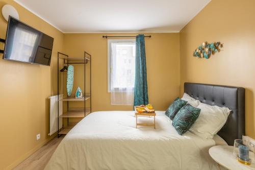 a bedroom with a large bed with a table on it at Appartements proche Paris Disney in Torcy
