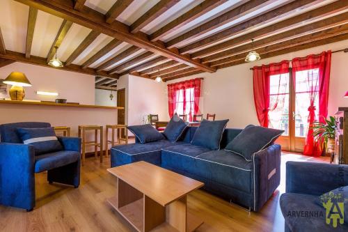 a living room with blue couches and a table at Gîte Scopa in Murol
