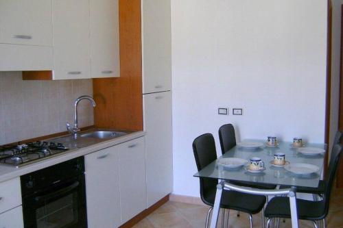 a kitchen with a table with chairs and a sink at Caulonia, 2 bed 1st Floor Apartment Close To Beach in Caulonia Marina