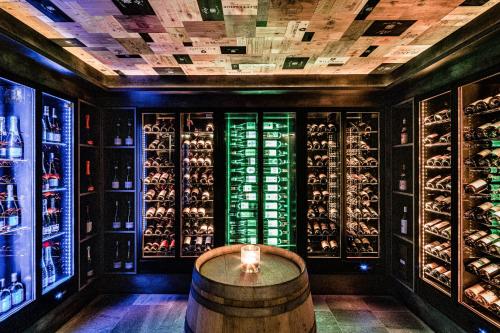 una sala de cata de vinos con barril y botellas de vino en Hotel Masl, en Valles
