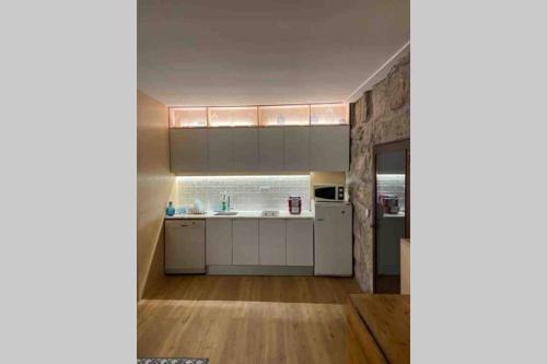 a kitchen with white cabinets and a counter at Porto-Braga Country side - private swimming pool in Alvarelhos
