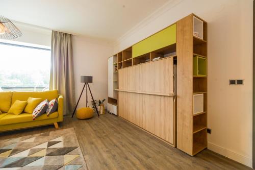 ポイアナ・ブラショフにあるSarah Deluxe Apartment in SILVER MOUNTAINのリビングルーム(黄色のソファ、本棚付)